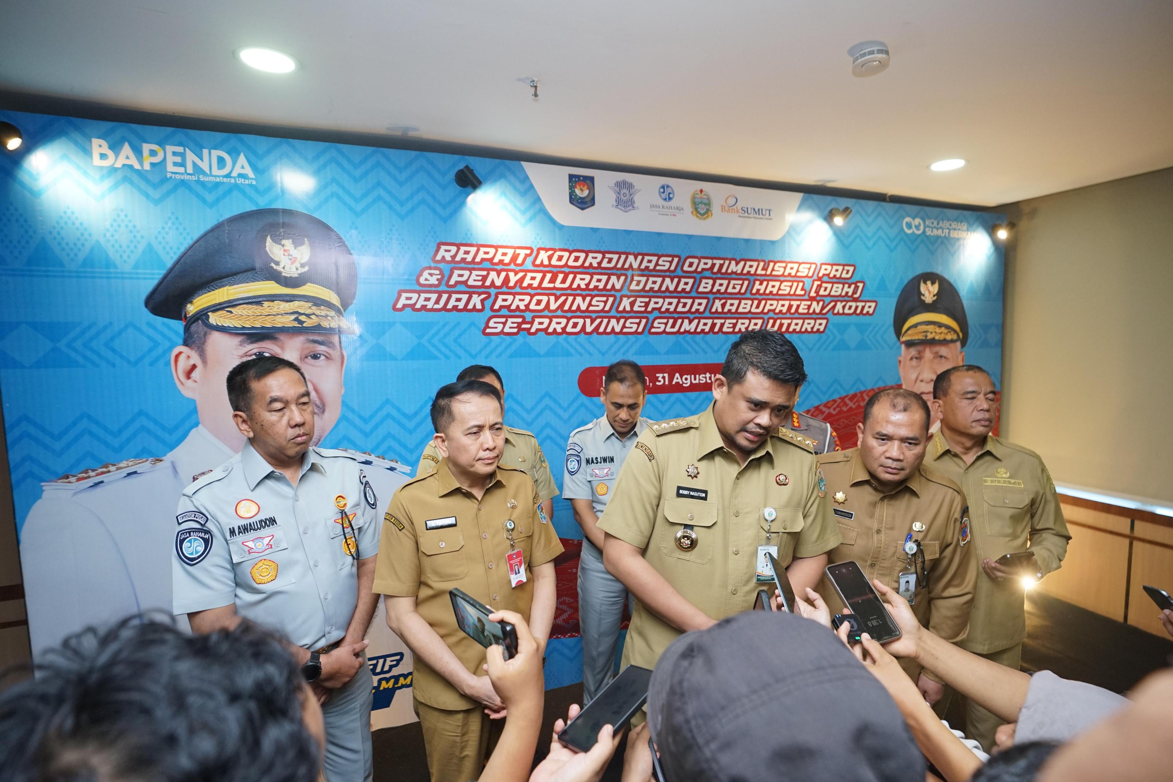 MEDAN — PT Jasa Raharja (persero) terus mendorong penguatan kolaborasi Tim Pembina Samsat Nasional untuk meningkatkan kepatuhan masyarakat, memperbaiki validitas data kendaraan, dan mengoptimalkan Pendapatan Asli Daerah (PAD). Hal itu disampaikan Direktur Utama Jasa Raharja, Muhammad Awaluddin, dalam Rapat Koordinasi Optimalisasi Pendapatan Asli Daerah dan Penyaluran Dana Bagi Hasil Pajak Provinsi se-Sumatera Utara, di Aula Raja Inal Siregar, Kantor Gubernur Sumatera Utara, Medan, Senin (31/8/2026).

Rapat dipimpin Gubernur Sumatera Utara, Bobby Nasution dan dihadiri oleh Direktur Jenderal Perhubungan Darat sekaligus Komisaris Utama PT Jasa Raharja, Irjen Pol. (Purn.) Aan Suhanan, Dirjen Bina Keuangan Daerah Kementerian Dalam Negeri, Agus Fatoni, Direktur Operasional Jasa Raharja, Ariyandi, Kasubdit STNK Ditregident Korlantas Polri, Kombes Pol. Dedy Suhartono, serta Kepala Bidang Evaluasi Pendapatan Bapenda Sumatera Utara, Sofyan Romi Wandy. Agenda tersebut juga diikuti jajaran Pemerintah Provinsi Sumatera Utara dan pemerintah kabupaten/kota se-Sumatera Utara. 

Direktur Utama Jasa Raharja, Muhammad Awaluddin menyampaikan, optimalisasi penerimaan pajak kendaraan bermotor membutuhkan kerja bersama seluruh pemangku kepentingan. Kolaborasi tersebut perlu diarahkan pada pembenahan data, perluasan akses pelayanan, dan peningkatan pemahaman masyarakat mengenai kewajiban pajak kendaraan. “Tentunya, membangun pelayanan yang mudah, transparan, dan dipercaya masyarakat adalah salah satu upaya kita bersama untuk mengoptimalkan pendapatan,” ujarnya.

Menurut Awaluddin, Jasa Raharja siap memperkuat sinergi dengan Bapenda dan Kepolisian melalui validasi data kendaraan, pengembangan kanal pelayanan, serta edukasi yang mendorong kepatuhan masyarakat. Ia mengatakan, kepatuhan masyarakat dalam membayar Pajak Kendaraan Bermotor (PKB) memiliki arti penting bagi pembangunan daerah. Sementara itu, pembayaran Sumbangan Wajib Dana Kecelakaan Lalu Lintas Jalan (SWDKLLJ) berperan dalam mendukung keberlanjutan perlindungan dasar bagi korban kecelakaan lalu lintas. “Ketika masyarakat memenuhi
kewajibannya, manfaatnya kembali kepada masyarakat melalui pembangunan daerah dan perlindungan dasar bagi korban kecelakaan,” tambahnya.

Dalam arahannya, Bobby Nasution menyoroti pentingnya pemerataan pembangunan daerah melalui kebijakan opsen pajak. Melalui skema tersebut, bagian penerimaan PKB disalurkan langsung ke kas pemerintah kabupaten dan kota berdasarkan potensi kendaraan di wilayah masing-masing. 
Bobby juga mengusulkan agar kemungkinan penyesuaian tarif PKB berdasarkan wilayah, dikaji. Opsi tersebut dinilai dapat mendorong masyarakat membeli dan mendaftarkan kendaraannya di daerah asal. Dengan demikian, potensi penerimaan pajak kendaraan tidak hanya terkonsentrasi di Kota Medan dan Kabupaten Deli Serdang.  

“Kalau dahulu dibagi ke daerah lain, tetapi sekarang itu sesuai jumlahnya. Makanya bagaimana jika di daerah tertentu untuk kendaraan itu, pajaknya kita rendahkan. “Sehingga, tidak semua orang membeli mobil ke Medan, misalnya. Dengan demikian, potensi penerimaan dari sektor pajak kendaraan dapat lebih merata antardaerah,” ujarnya.

Berdasarkan data Bapenda Sumatera Utara hingga Agustus 2026, realisasi penerimaan pajak daerah mencapai 55,41 persen atau sekitar Rp3,86 triliun dari target Rp6,96 triliun. Bobby mengapresiasi capaian tersebut. Namun, ia meminta seluruh jajaran pemerintah daerah mempercepat pencapaian target penerimaan hingga akhir tahun.

Tingkat Kepatuhan Masyarakat 

Dalam kesempatan yang sama, Aan Suhanan menyoroti tingkat kepatuhan pembayaran PKB di Sumatera Utara yang masih berada di angka 36,89 persen. Angka tersebut berada di bawah rata-rata nasional sebesar 47,72 persen. “Ini merupakan tantangan besar mengingat PKB dan BBNKB menyumbang hampir 50% atau sekitar Rp2,9 triliun dari total PAD Sumut,” ujarnya.  Aan juga menekankan pentingnya rekonsiliasi dan pemutakhiran sekitar 189.000 data kendaraan. Sebagian data tersebut berkaitan dengan kendaraan yang sudah tidak beroperasi, rusak, atau berstatus barang bukti di kantor kepolisian. “Pemutakhiran data ini sangat vital agar database menjadi valid untuk mengevaluasi kinerja secara akurat,” tambahnya.

Aan meminta tiga unsur Tim Pembina Samsat, yakni Bapenda, Kepolisian, dan Jasa Raharja, memperkuat konsolidasi dalam tiga hingga empat bulan tersisa menjelang akhir tahun. Upaya meningkatkan kepatuhan juga perlu dilakukan melalui pendekatan yang humanis dan persuasif.  Sementara itu, Kasubdit STNK Ditregident Korlantas Polri, Kombes Pol. Dedy Suhartono, menekankan pentingnya integrasi pelayanan Samsat yang lebih solid, responsif, dan sesuai dengan kebutuhan masyarakat. Sejumlah langkah yang didorong meliputi perluasan layanan Samsat Keliling hingga wilayah yang sulit dijangkau, penyediaan kanal pembayaran yang lebih fleksibel, serta edukasi mengenai pentingnya balik nama kendaraan. 

Dedy juga mendorong interkoneksi basis data antara Bapenda, Kepolisian, dan Jasa Raharja. Rekonsiliasi data secara berkala dibutuhkan untuk memastikan legalitas dan akurasi data kendaraan maupun wajib pajak. “Aplikasi SIGNAL (Samsat Digital Nasional) didorong sebagai solusi transaksi elektronik utama masyarakat tanpa batasan waktu dan tempat,” ujarnya.

Adapun Agus Fatoni mengatakan, PAD merupakan salah satu indikator kemandirian fiskal daerah. Untuk meningkatkan penerimaan, pemerintah daerah didorong menjalankan lima strategi, yakni intensifikasi, ekstensifikasi, peningkatan kapasitas sumber daya manusia, digitalisasi, dan inovasi progresif.  Agus juga memaparkan sejumlah alternatif pembiayaan kreatif. Alternatif tersebut mencakup optimalisasi PAD dan dana transfer daerah, revitalisasi BUMD dan BLUD, pemanfaatan aset daerah, pinjaman atau obligasi daerah, sukuk daerah, serta kerja sama pemerintah dengan badan usaha. Pilihan lainnya adalah pemanfaatan dana tanggung jawab sosial perusahaan dan kolaborasi dengan Baznas untuk mendukung program pengentasan kemiskinan. 

“Kami memberikan apresiasi khusus dan mendorong replikasi serta standardisasi berbagai inovasi pelayanan Samsat yang telah dirintis di Sumatera Utara, seperti Samsat Drive-Thru hasil kolaborasi dengan Bank Sumut,” ungkap Agus. 
